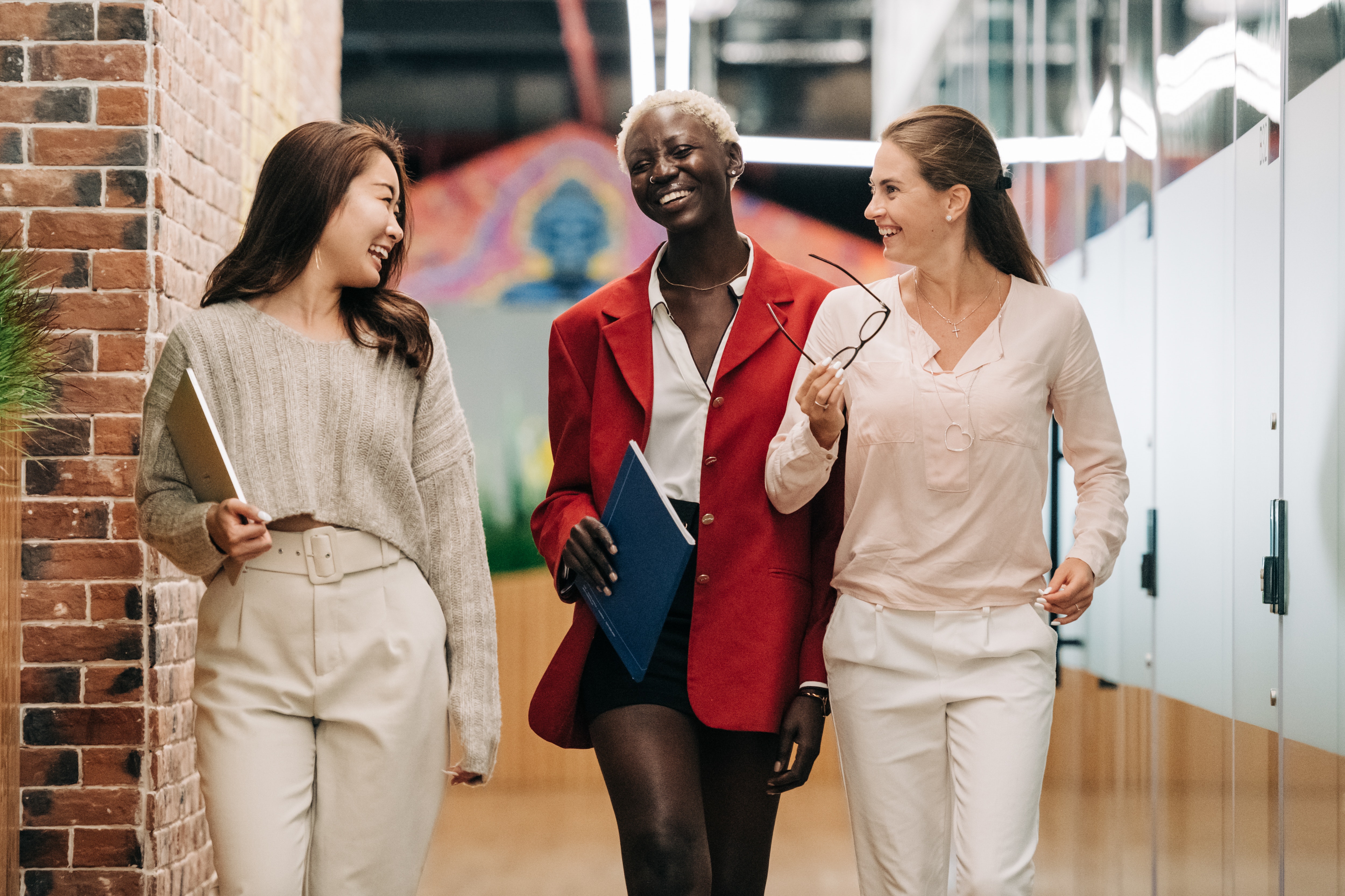 Three female office workers looking happy